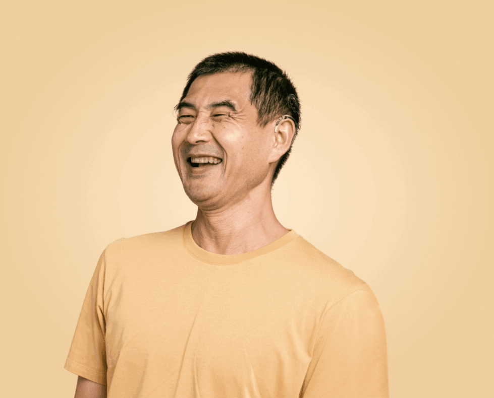 Premium senior wearing an invisible AI hearing aid for auditory brain training and cognitive health support